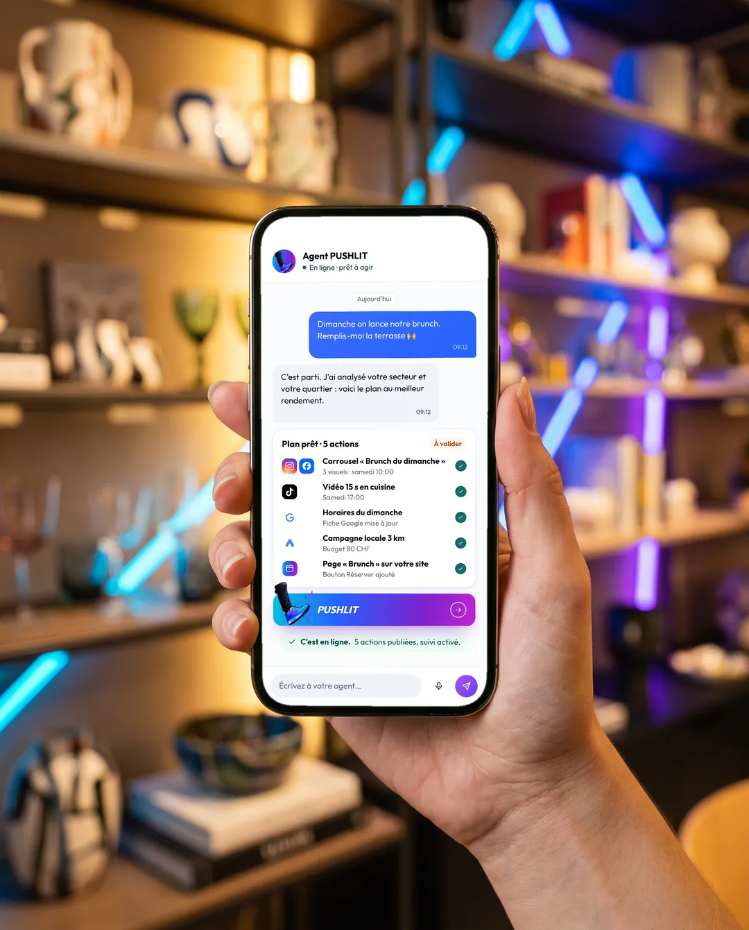 Main d'une commerçante tenant son téléphone avec l'app PUSHLIT dans sa boutique